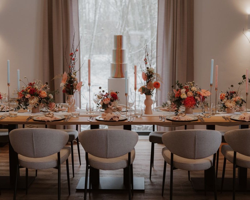 Gedeckter Tisch mit Hochzeitstorte im Hintergrund für eine Hochzeitsfeier im Reitpark Mergenthau