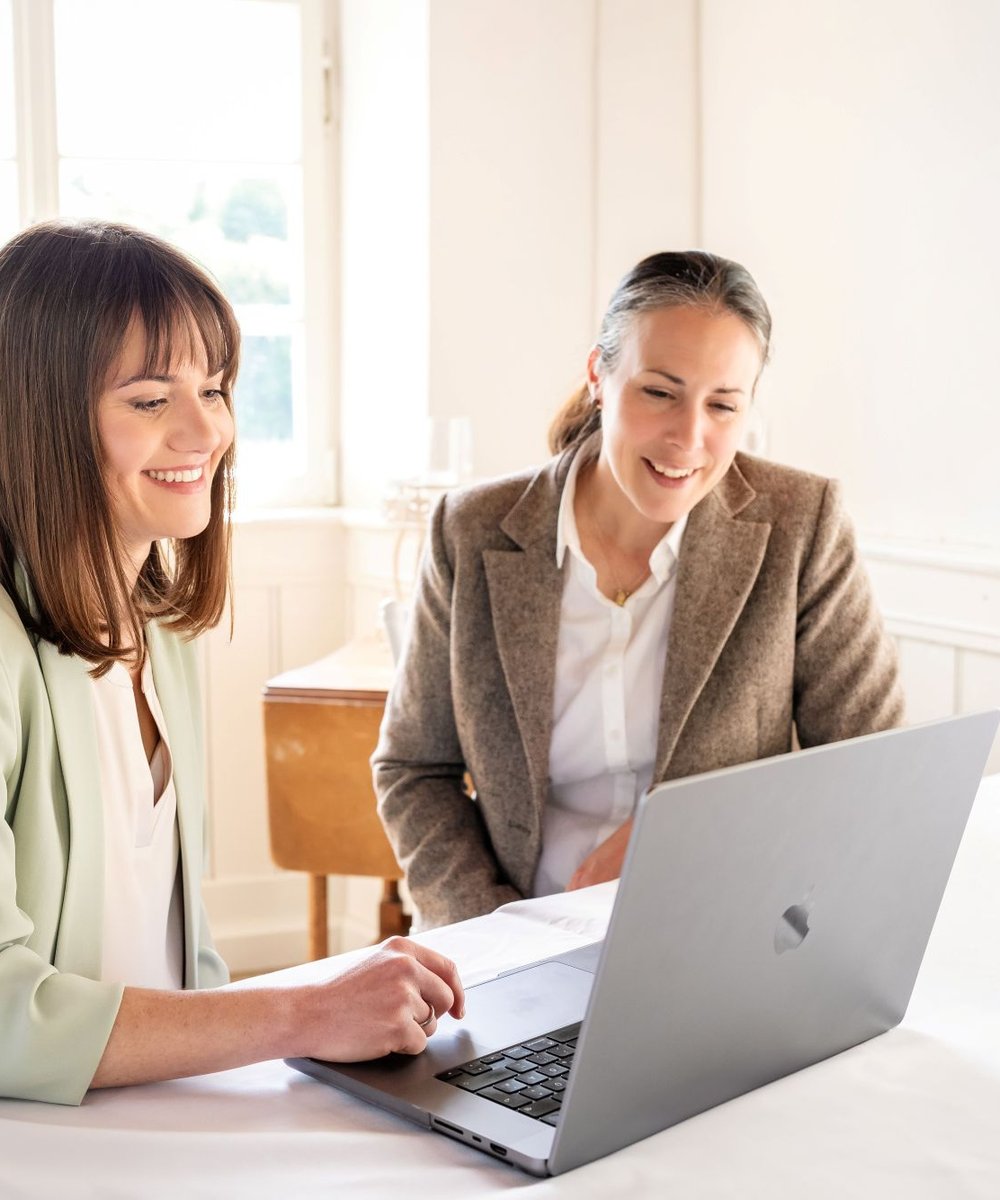 Unserehochzeitslocation.de hilft Hochzeitslocations, online sichtbarer zu werden – zwei Frauen besprechen am Laptop die Optimierung des Location-Profils