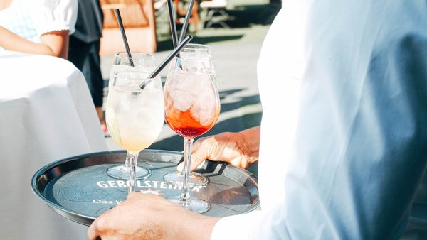 Kellner serviert Getränke bei einer Hochzeit in der Hochzeitslocation Sportalm Gipfelglück in Lüdenscheid